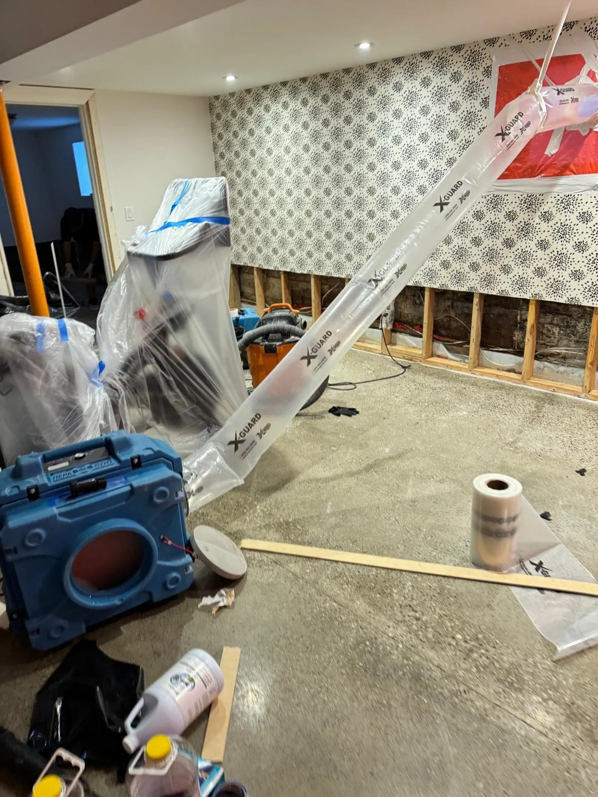 Work area sealed with plastic and ducted to an air scrubber during cleanup