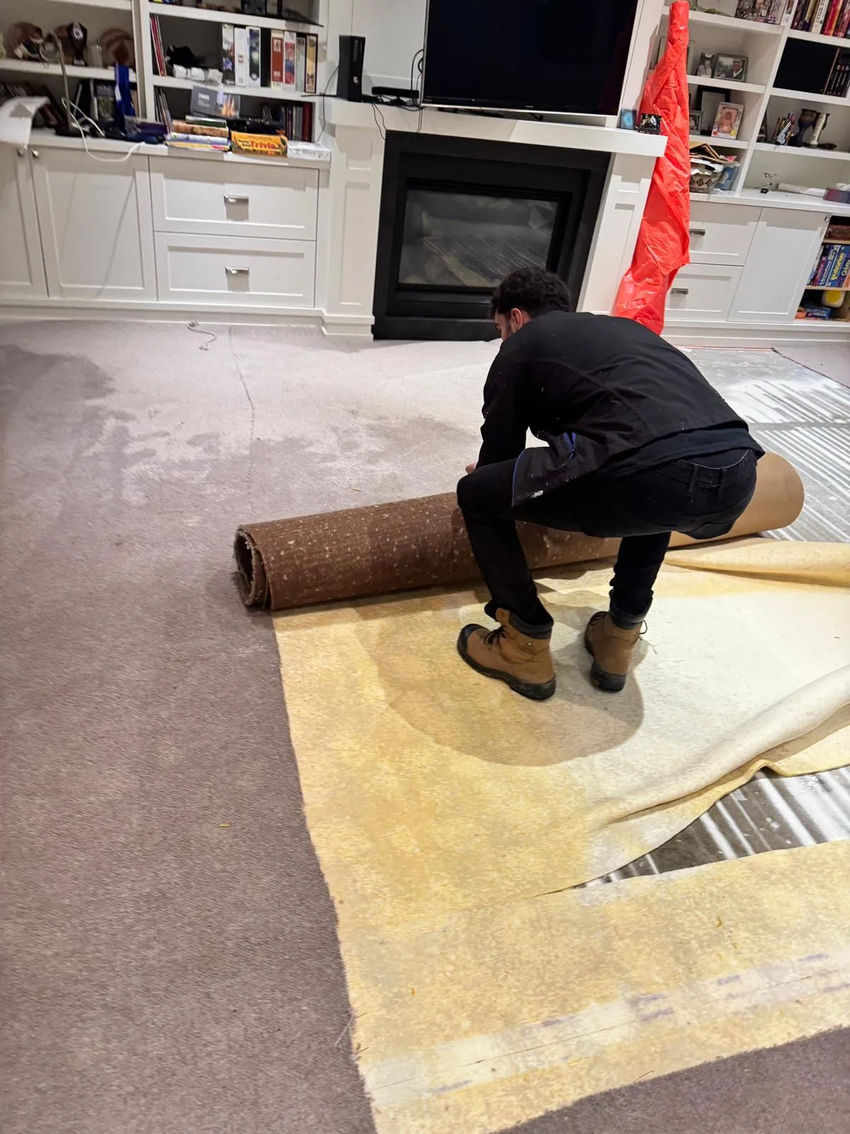 Technician rolling up soaked carpet